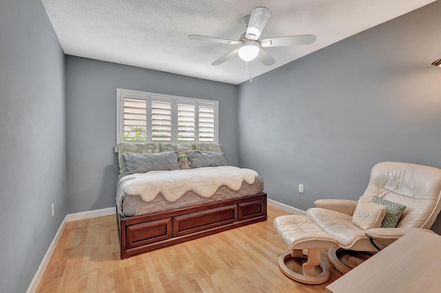 bedroom featuring a textured ceiling, ceiling fan, and light wood-type flooring