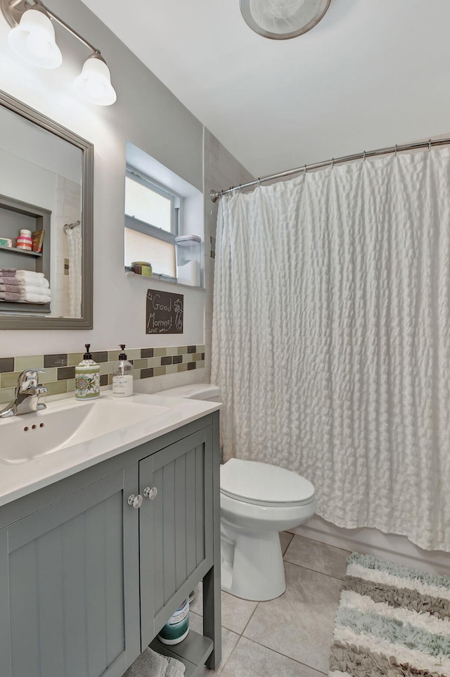 bathroom with toilet, a shower with shower curtain, vanity, tile patterned floors, and tasteful backsplash