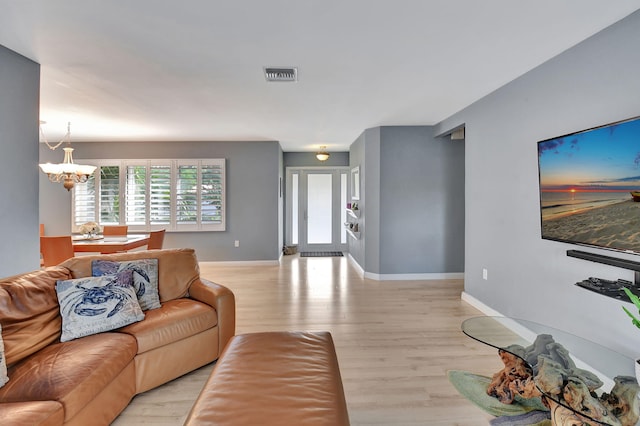 living room featuring light hardwood / wood-style floors and a notable chandelier