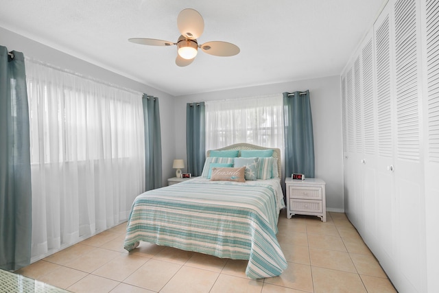 tiled bedroom featuring ceiling fan