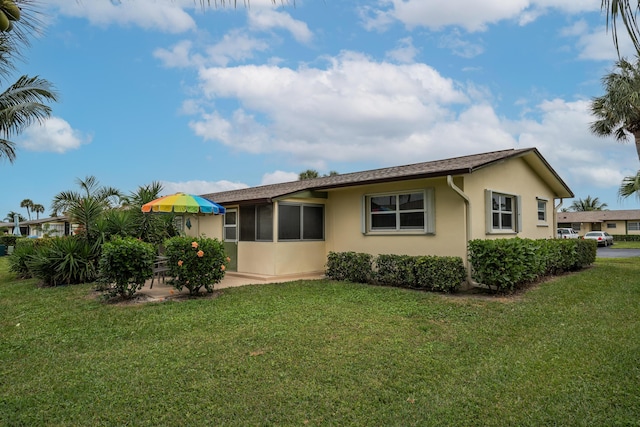 rear view of property featuring a lawn