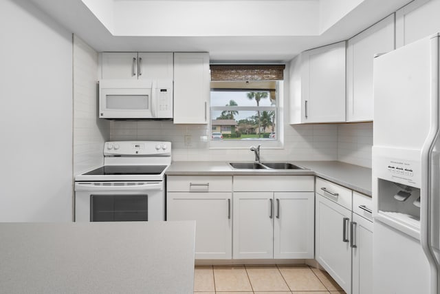 kitchen featuring white appliances, white cabinetry, and sink