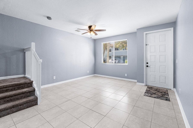 tiled foyer entrance featuring ceiling fan and a textured ceiling