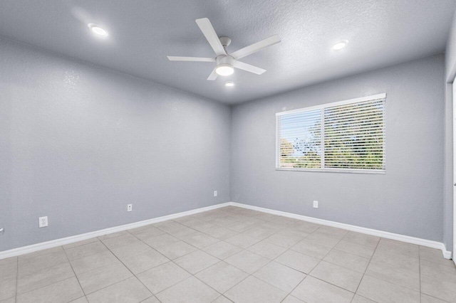 empty room with ceiling fan and a textured ceiling