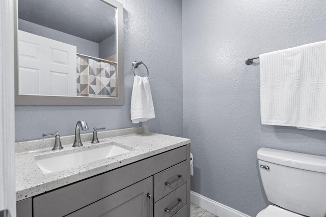 bathroom featuring a shower with curtain, vanity, and toilet