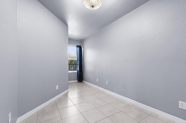 empty room featuring light tile patterned floors and a textured ceiling