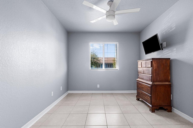 interior space with ceiling fan, light tile patterned floors, and a textured ceiling