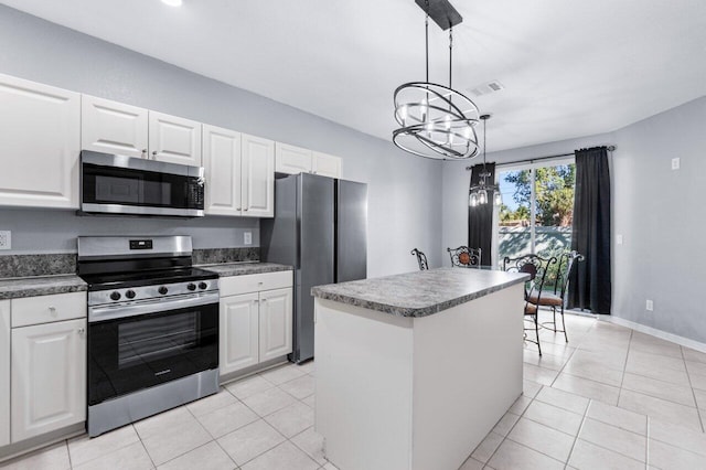 kitchen with white cabinets, pendant lighting, a center island, and stainless steel appliances