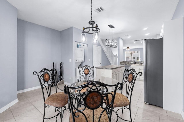 dining area with ceiling fan with notable chandelier and light tile patterned flooring