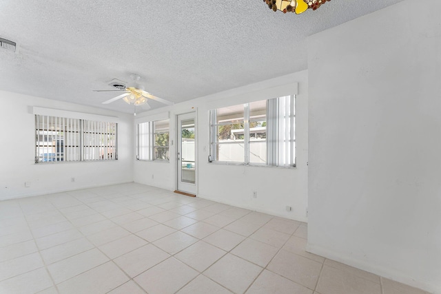 spare room with ceiling fan, light tile patterned floors, and a textured ceiling