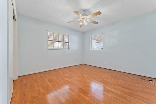 spare room with ceiling fan, a textured ceiling, and light wood-type flooring