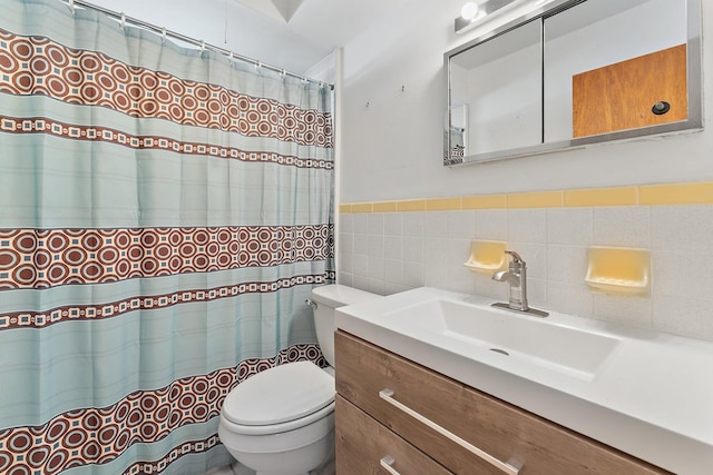 bathroom with vanity, toilet, and tile walls