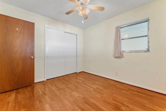 unfurnished bedroom featuring ceiling fan, light wood-type flooring, and a closet