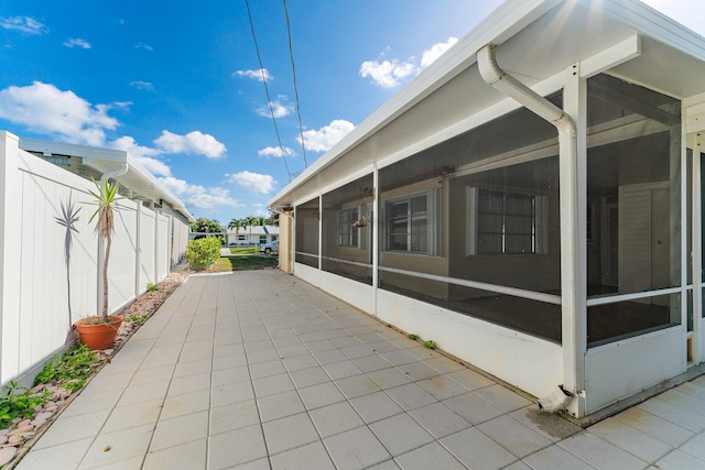 view of side of home featuring a patio and a sunroom