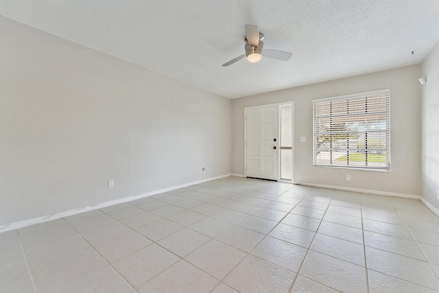 tiled spare room with a textured ceiling and ceiling fan