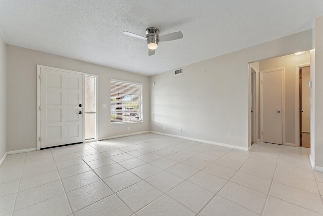 spare room featuring light tile patterned floors, a textured ceiling, and ceiling fan