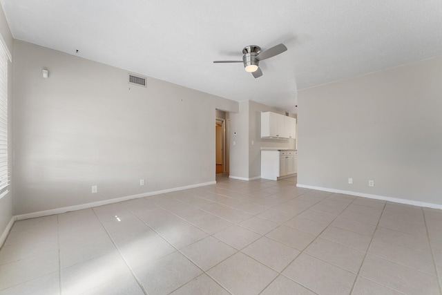 empty room with ceiling fan and light tile patterned floors