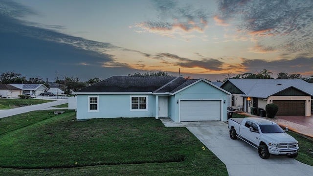 ranch-style house with a garage and a lawn