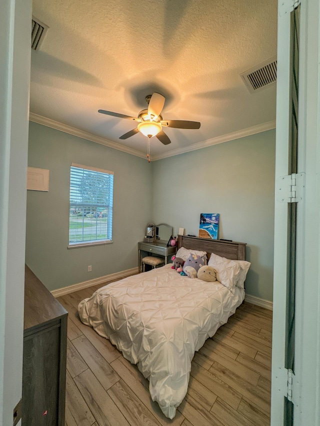 hallway featuring a textured ceiling, light hardwood / wood-style floors, and crown molding