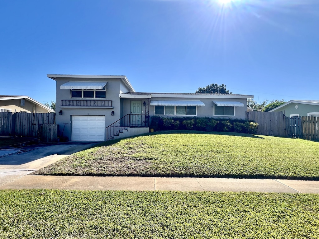 view of front of property with a front yard and a garage