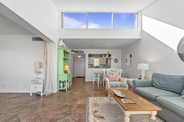 living room featuring a chandelier, a towering ceiling, and a healthy amount of sunlight