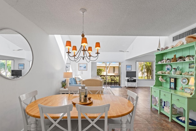 dining room with a textured ceiling, a chandelier, and vaulted ceiling