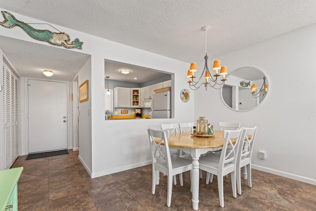 dining area featuring a chandelier and a textured ceiling