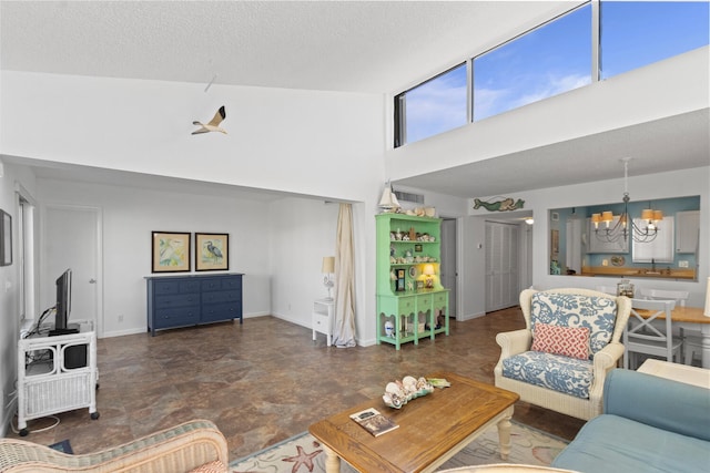 living room featuring a chandelier, a high ceiling, and a textured ceiling