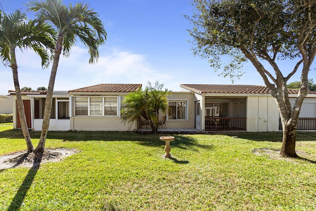 view of front of house with a sunroom and a front lawn