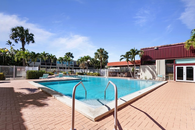 view of swimming pool featuring french doors and a patio