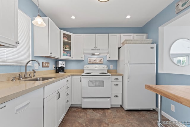 kitchen featuring white cabinets, white appliances, hanging light fixtures, and sink