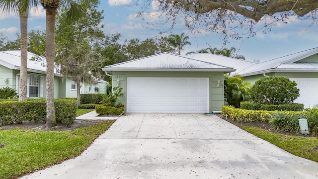 1625 SW Waterfall Blvd, Palm City, FL 34990 - view of property exterior with an attached garage, stucco siding, metal roof, and concrete driveway