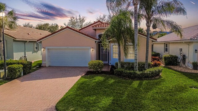 view of front of home with a front yard and a garage