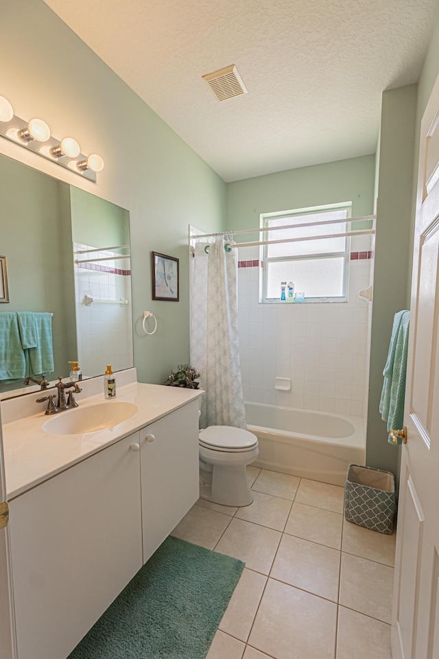 full bathroom with tile patterned floors, toilet, a textured ceiling, vanity, and shower / bath combo