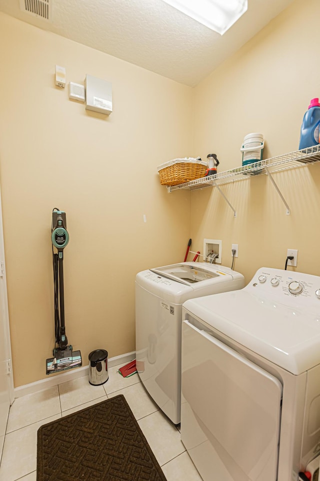 laundry room featuring light tile patterned floors and washing machine and clothes dryer