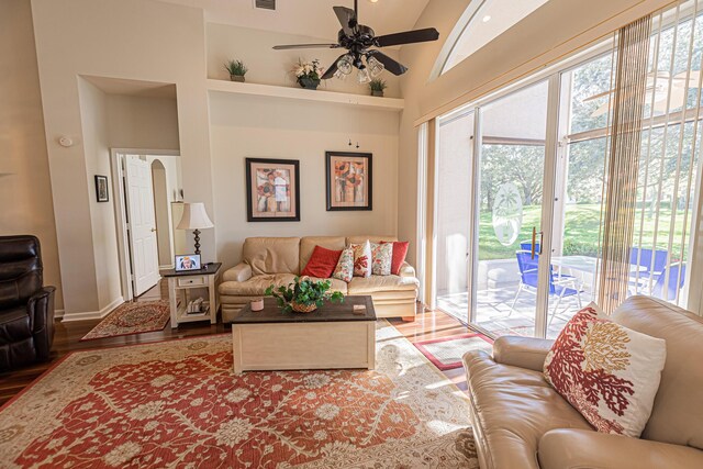 living room with hardwood / wood-style floors, ceiling fan, and lofted ceiling