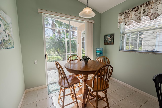 dining room with light tile patterned flooring and vaulted ceiling