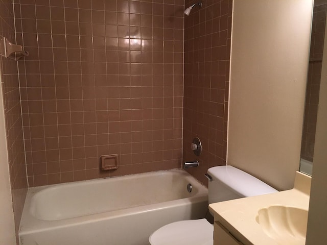 full bathroom with tiled shower / bath combo, toilet, and vanity