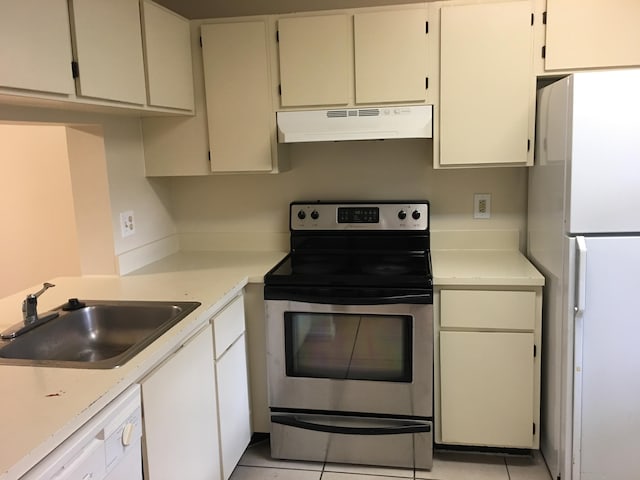 kitchen featuring light tile patterned flooring, white appliances, white cabinets, and sink