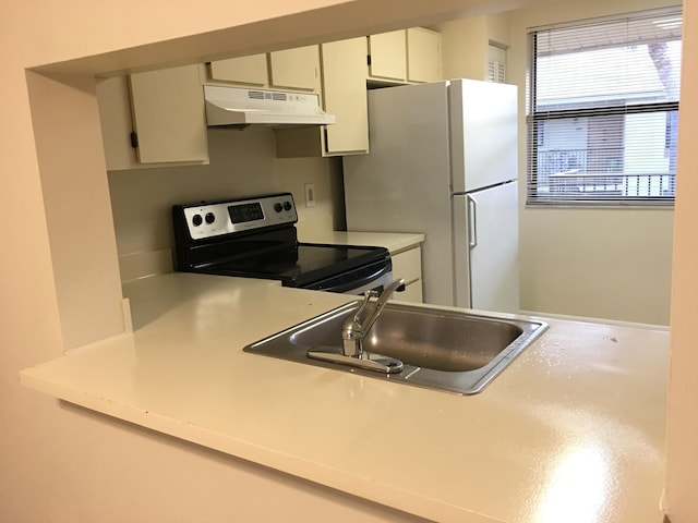 kitchen featuring white fridge, sink, white cabinetry, and stainless steel range with electric cooktop