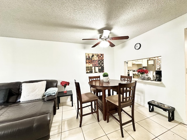 tiled dining space with ceiling fan and a textured ceiling