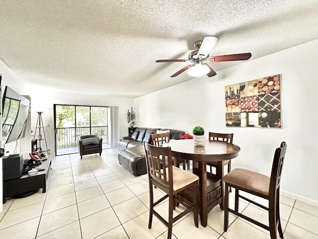 dining space featuring ceiling fan, light tile patterned flooring, and a textured ceiling