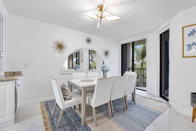 dining area with light tile patterned floors, a notable chandelier, and expansive windows