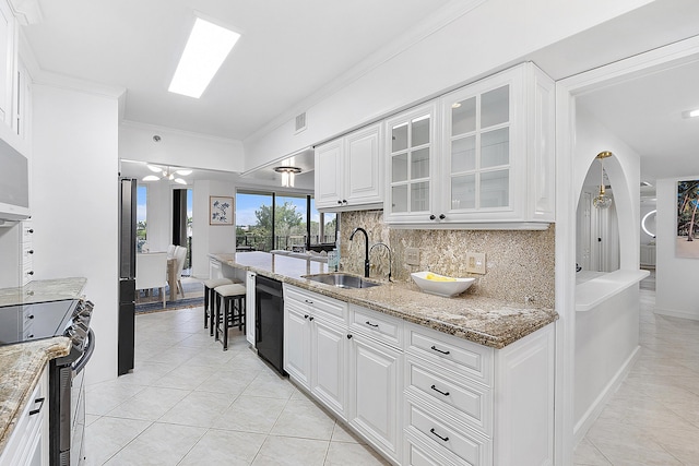 kitchen featuring sink, stainless steel appliances, white cabinetry, and light stone counters