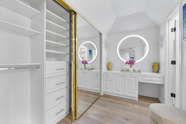 bathroom with lofted ceiling, wood-type flooring, and vanity