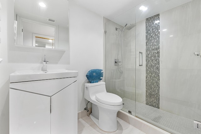 bathroom with toilet, vanity, tile patterned flooring, and a shower with shower door