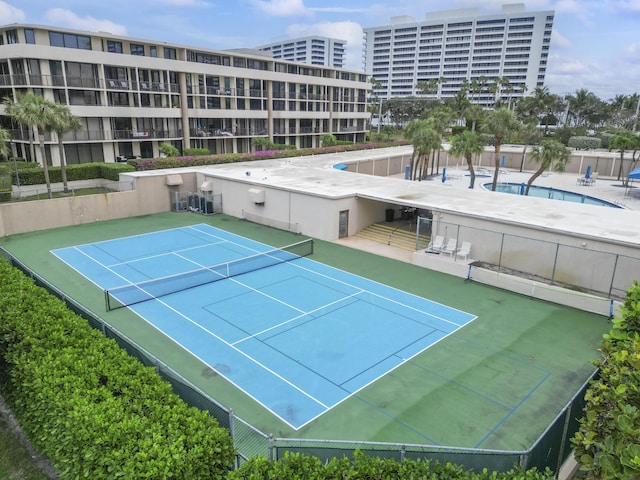 view of tennis court with a community pool