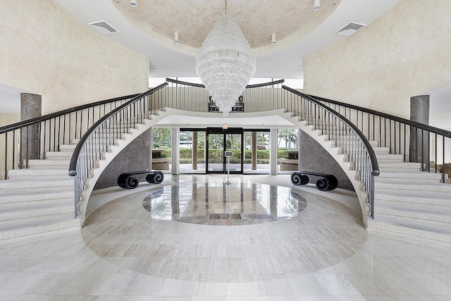 foyer entrance with a high ceiling, an inviting chandelier, and french doors