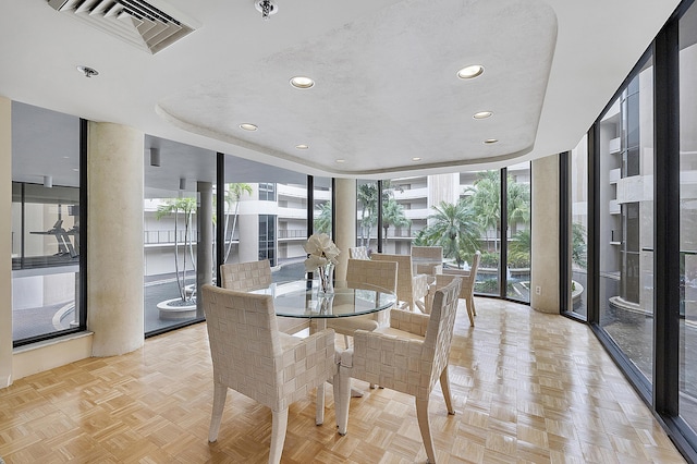 dining space with floor to ceiling windows and light parquet flooring