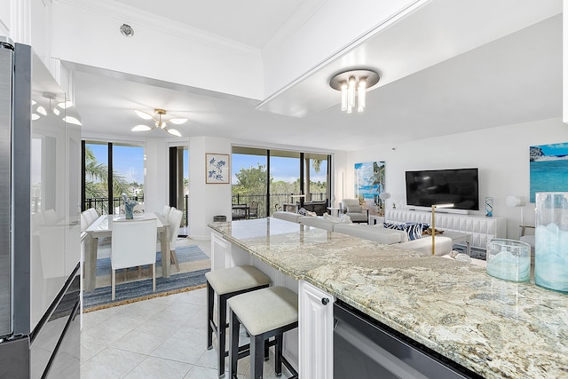 kitchen featuring white cabinets, a kitchen bar, light tile patterned floors, light stone countertops, and crown molding